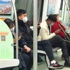 ركاب في القطار في الصين يرتدون أقنعة.