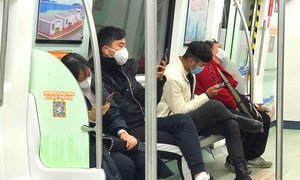 中国深圳的乘客在乘坐地铁时戴着口罩。