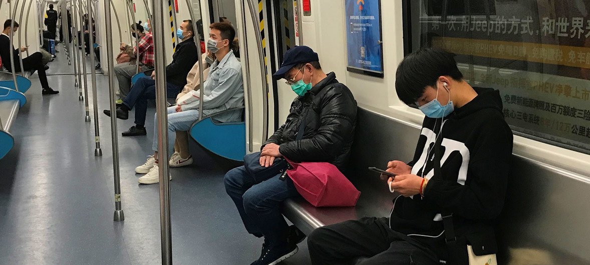 中国深圳的乘客在乘坐地铁时戴着口罩。