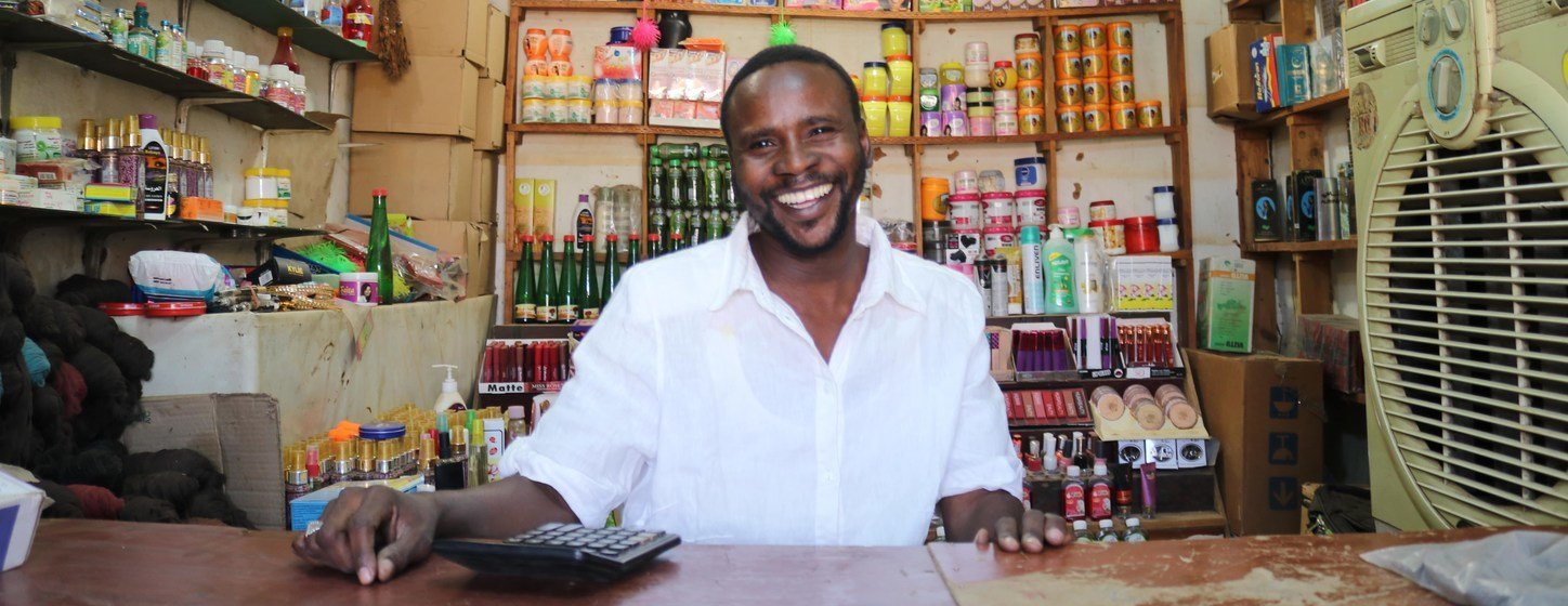 IOM helped Mohammed Ahmed to set up a shop in Omduram market, near Khartoum, Sudan. The initiative involves the use of mobile money to buy goods