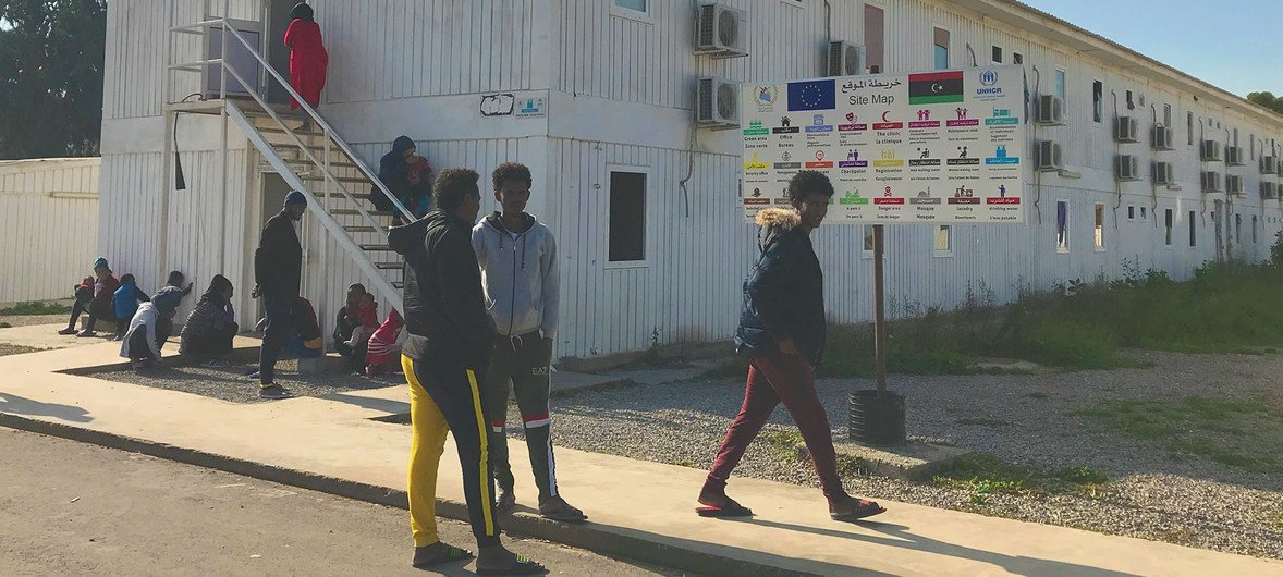 Refugiados caminando en los alrededores fuera de un centro de reunión y salida de ACNUR en Trípoli, Libia.