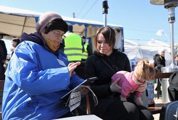 Сотрудники МОМ опрашивают людей, которые были вынуждены покинуть свои дома и спасаться бегством   