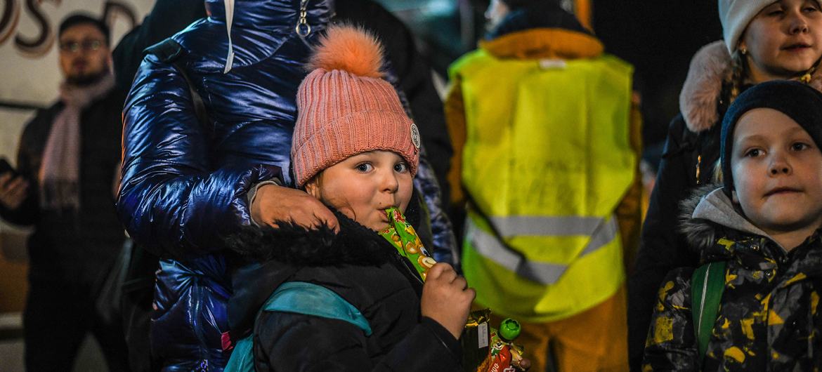 Refugees from Ukraine wait for a bus to continue their journey after crossing the Polish border to Medyka.