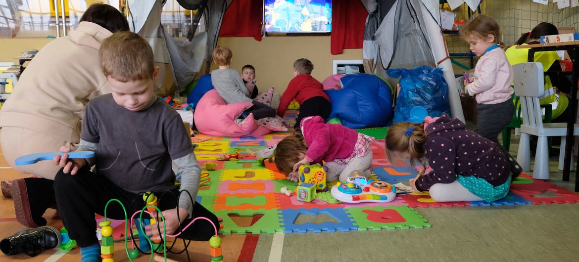 Crianças brincam em centro esportivo na Polônia que serve de abrigo para ucranianos. 