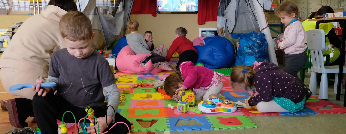 Children learn and play in the corner of a school gymnasium in Poland, set up to host refugee families who have fled the war in Ukraine.