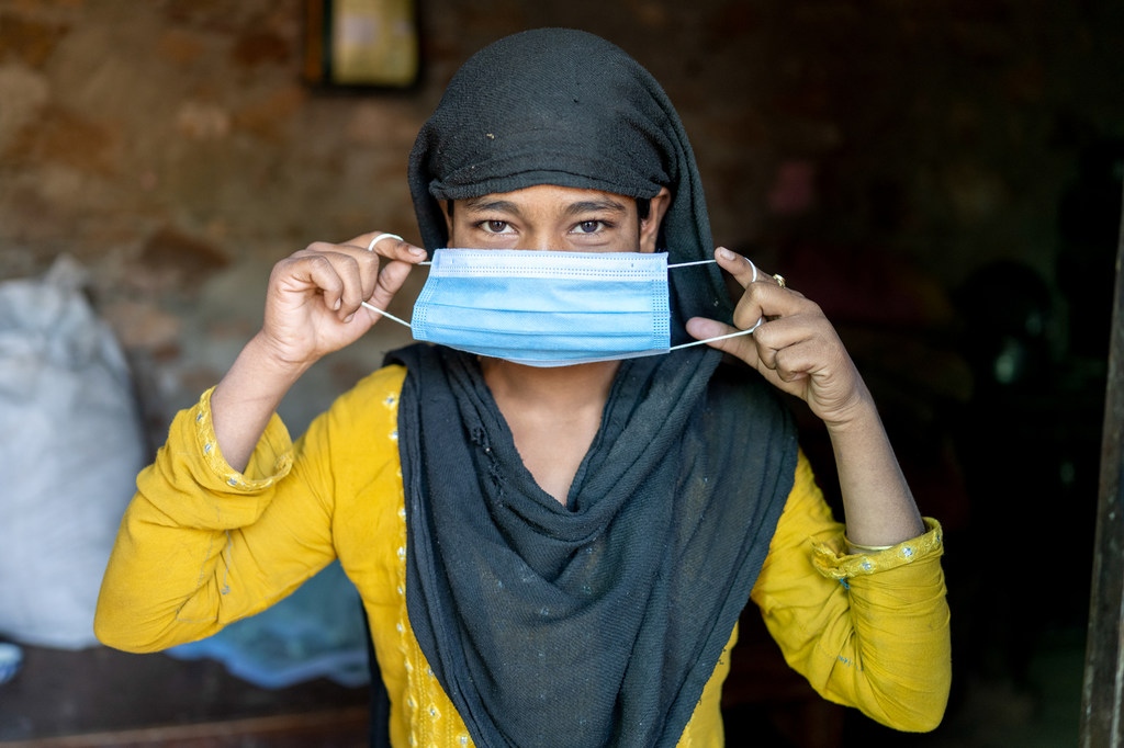 Una mujer en la India se coloca una mascarilla como protección contra el COVID-19.