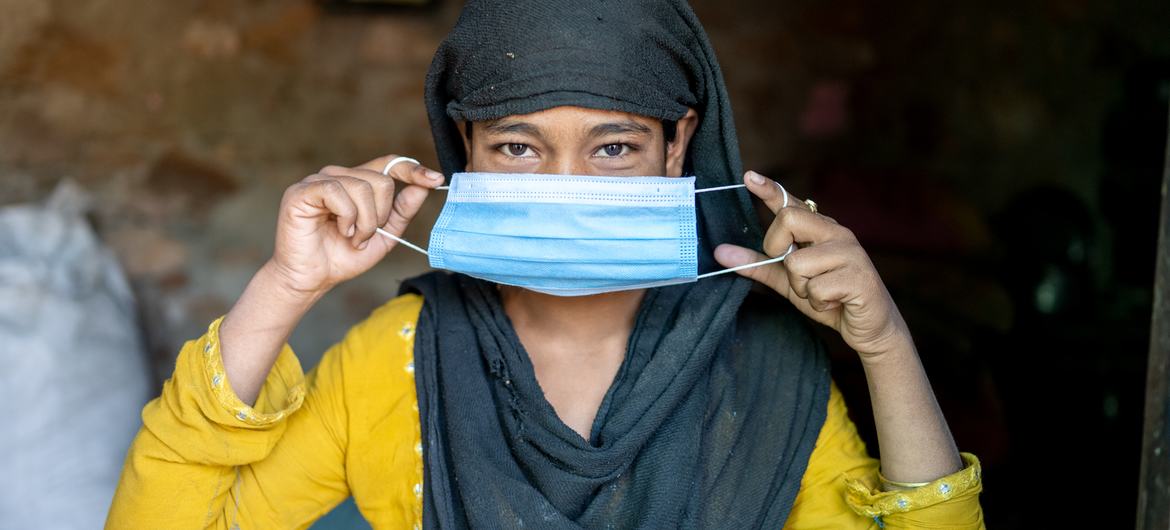 Una mujer en la India se coloca una mascarilla como protección contra el COVID-19.