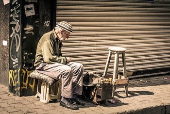 Un hombre de edad limpia zapatos en Turquía para mantenerse.