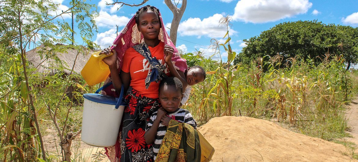 Une mère et ses enfants, qui ont été déplacés par le conflit, vont chercher de l'eau dans un camp temporaire dans le district de Montepuez, Cabo Delgado, Mozambique.