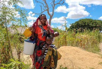 Une mère et ses enfants, qui ont été déplacés par les violences, vont chercher de l'eau dans un camp temporaire dans le district de Montepuez, Cabo Delgado, Mozambique.