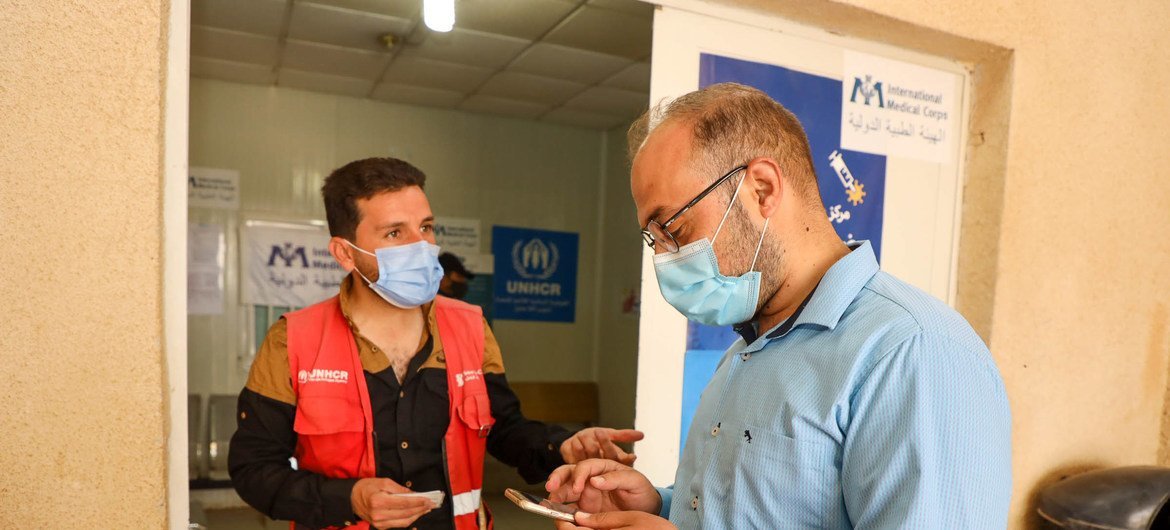 Na Jordania, voluntário ajuda no processo de vacinação. 