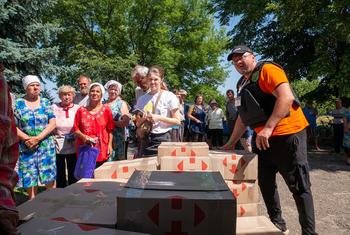 यूक्रेन के ख़ारकीव में युद्ध प्रभावित लोगों को विश्व खाद्य कार्यक्रम की तरफ़ से खाद्य पैकेट बाँटे जाते हुए.