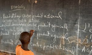 Un niño refugiado burundés escribe en el pizarrón de la escuela primaria del campamento de Nyarugusu, en Tanzania.