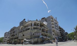 A child flies a kite on a street in the Gaza Strip where an Israeli airstrike took place.