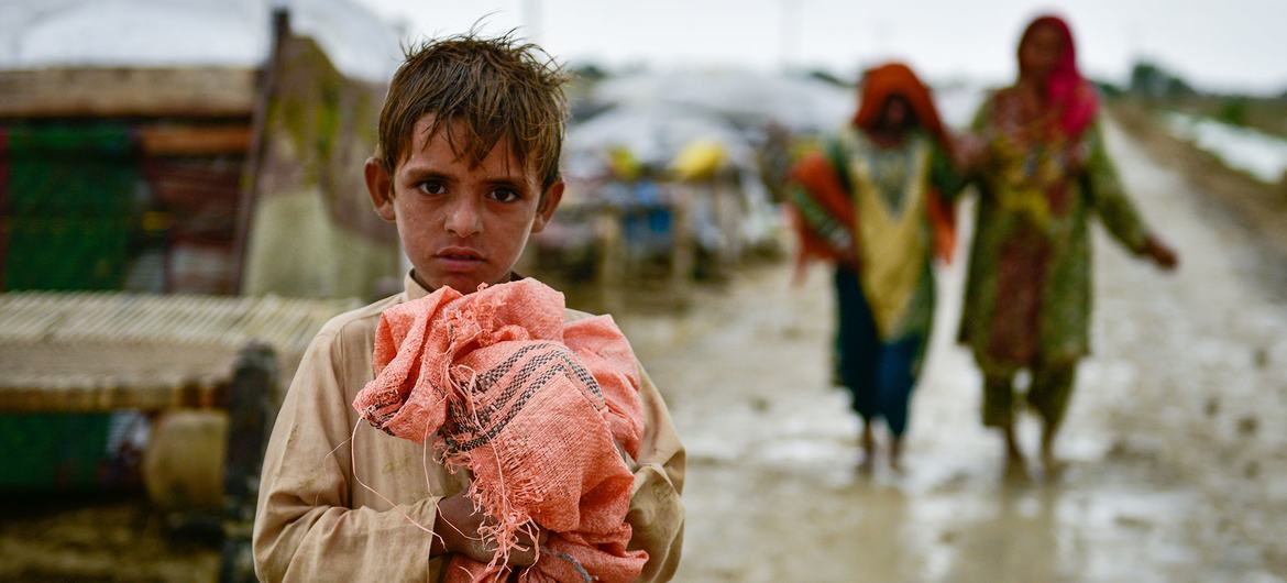Un niño se aferra a sus pertenencias mientras las familias se trasladan a zonas más seguras tras las inundaciones en la provincia de Baluchistán, Pakistán.