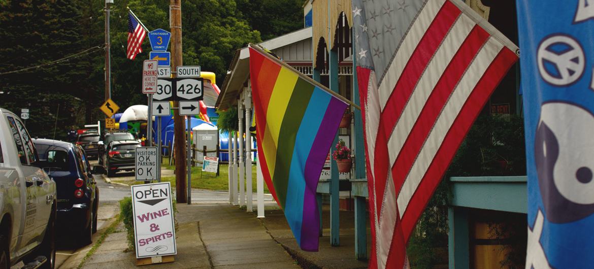 The Rainbow Pride flag is dispayed alongside the US flag in Chautauqua, New York in the USA.