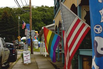 The Rainbow Pride flag is dispayed alongside the US flag in Chautauqua, New York in the USA.