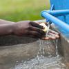 تلميذة في مدرسة في أوغندا تغسل يديها بصابون الغسيل في مرفق لغسل الأيدي.
