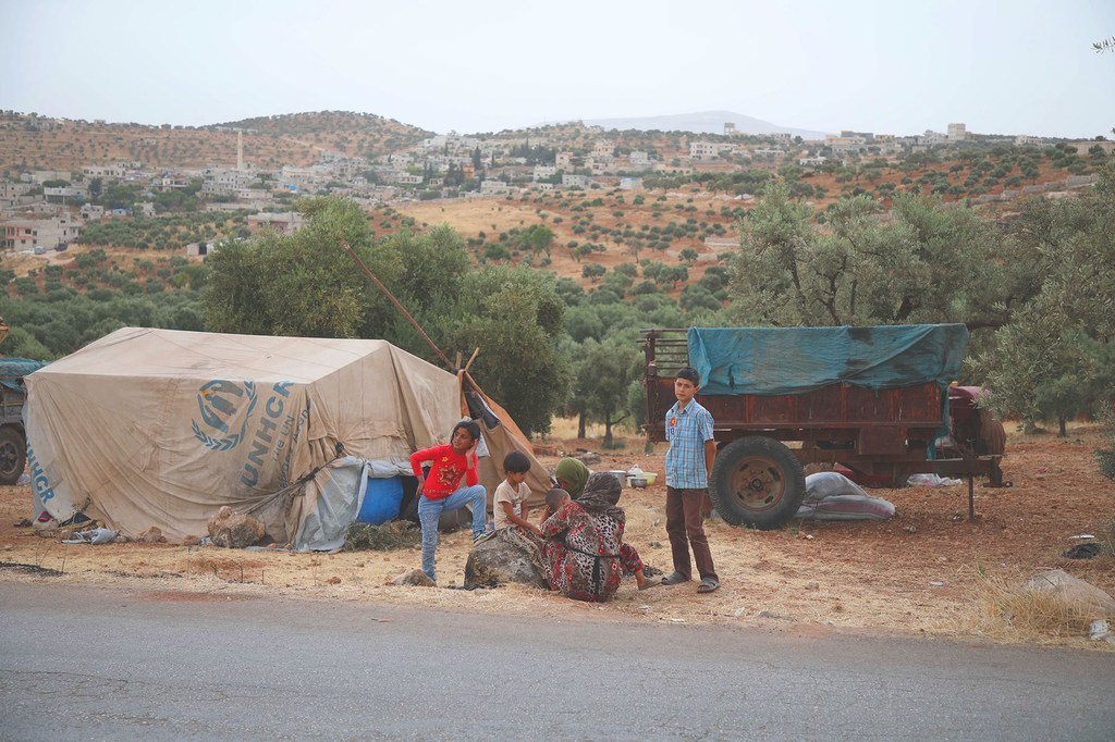 أسرة فرت من الأعمال العدائية في إدلب تقيم مخيما مؤقتا في قرية عقربات قرب الحدود التركية (3 حزيران/يونيو 2019)