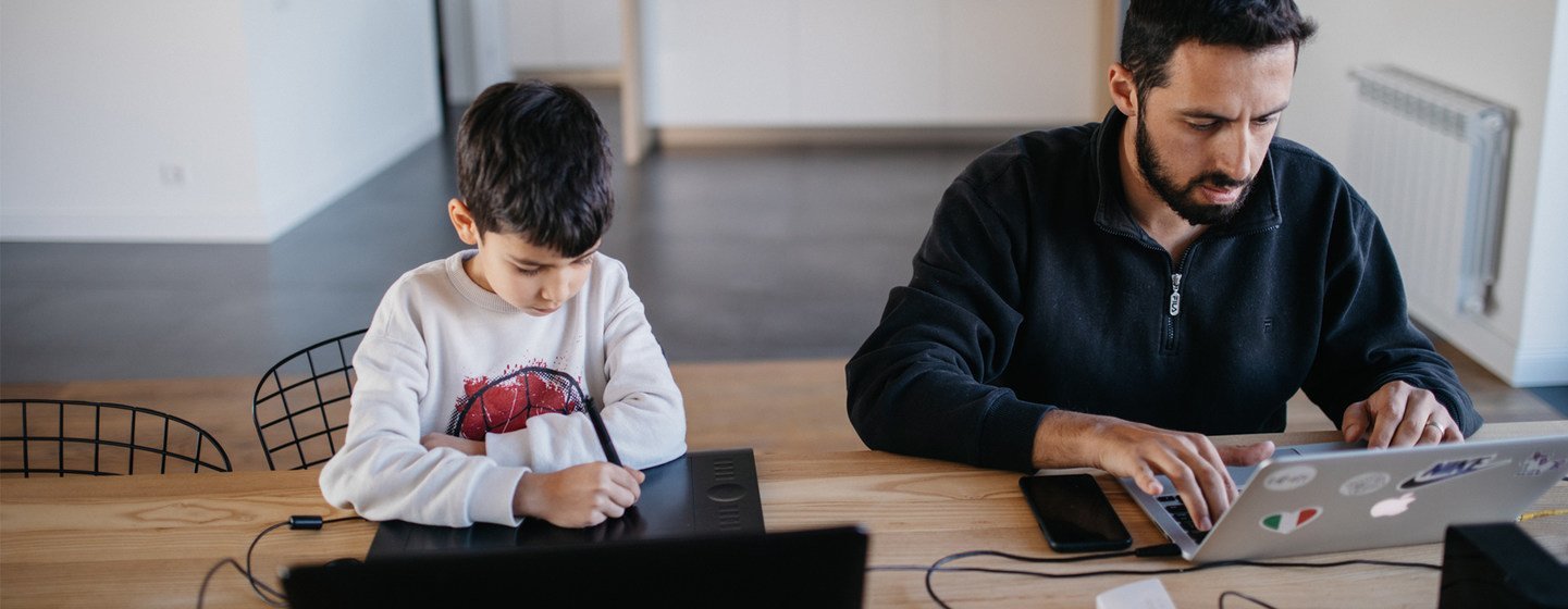 On 14 April 2020 in Yerevan in Armenia, Danny, 7, sits at a computer as his Arthur Gevorgyan works.