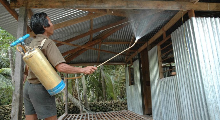 عامل يقوم برش مبيد حشري على أسطح ملجأ للسيطرة على انتشار البعوض والتخفيف من مخاطر انتقال الملاريا.