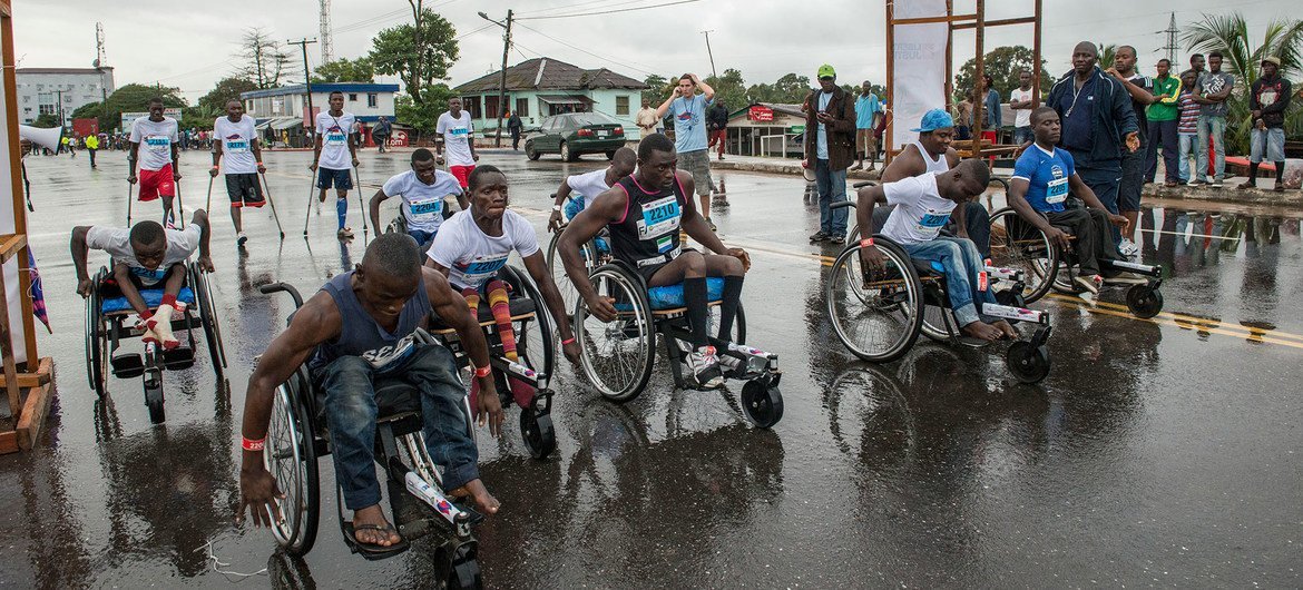 在利比里亚蒙罗维亚市中心举行的10公里小型残疾人马拉松比赛开始时，利比里亚残疾运动员推着轮椅前行（档案照片）。