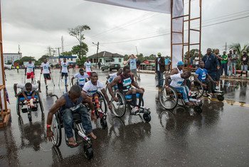 Des athlètes libériens handicapés avancent leur fauteuil roulant vers la ligne de départ d'un mini-marathon de 10 km pour les personnes handicapées dans le centre de Monrovia, au Libéria.