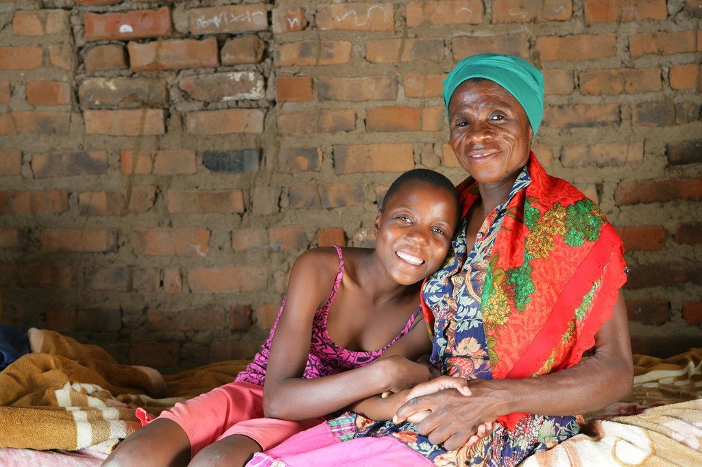 Una mujer seropositiva sentada en su casa con su nieta en Mangwe (Zimbabue).