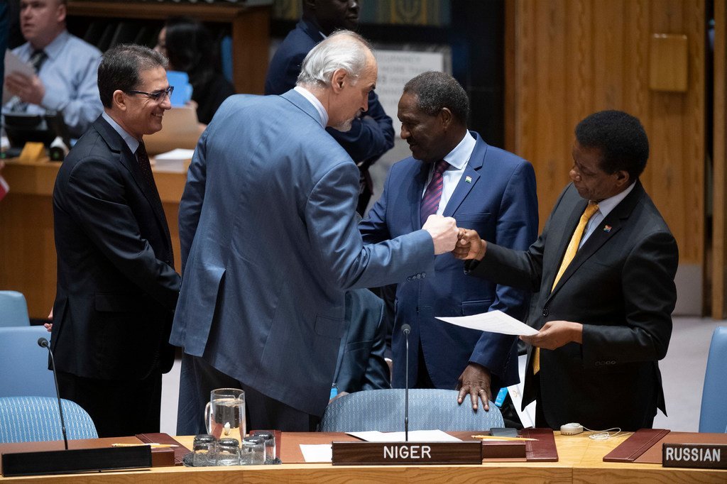 1月10日，安理会叙利亚问题会议开始前，叙利亚常驻联合国代表贾法里（左二）与南非常驻联合国代表马吉拉碰拳。