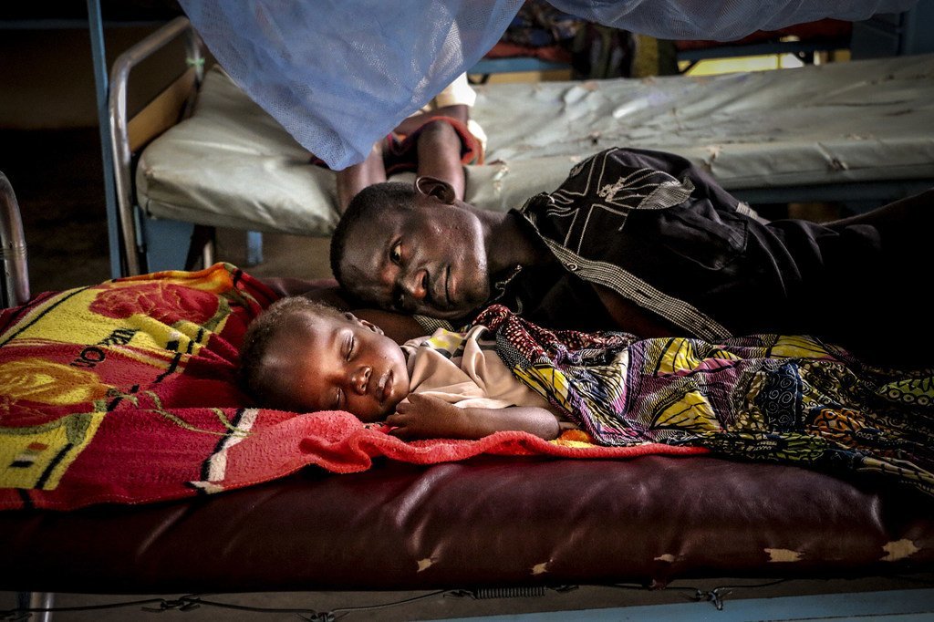 Un père se repose avec son fils à l'hôpital pédiatrique de Bangui, dans la capitale de la République centrafricaine.