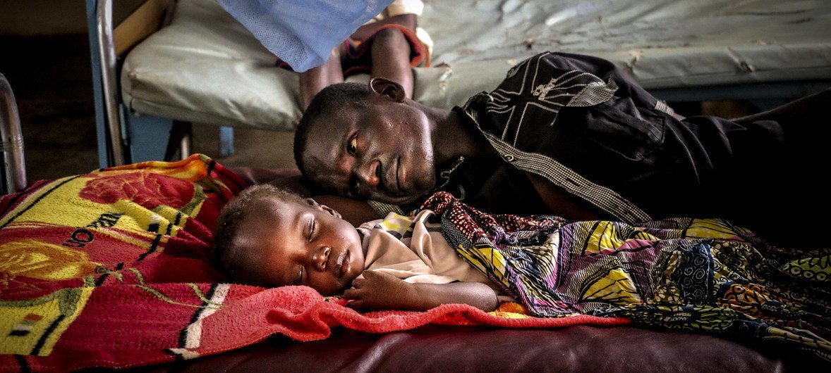Un père se repose avec son fils, qui souffre de malnutrition en raison du conflit, à l'hôpital pédiatrique de Bangui, dans la capitale de la République centrafricaine.