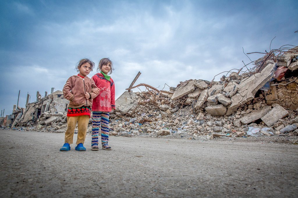 فتاتان تسيران على أنقاض مبان مدمرة في مدينة الموصل في العراق.