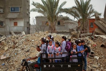 Des enfants palestiniens sur un tuk-tuk les amenant sur le chemin de l'école.
