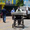 Un trabajador sanitario traslada bombas de oxígeno  en un carrito, en Guwahati, (India).