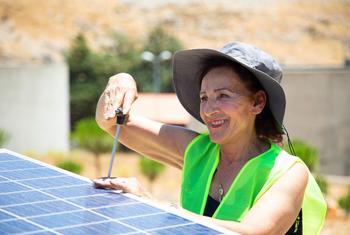 一名黎巴嫩妇女在屋顶安装太阳能电池板。