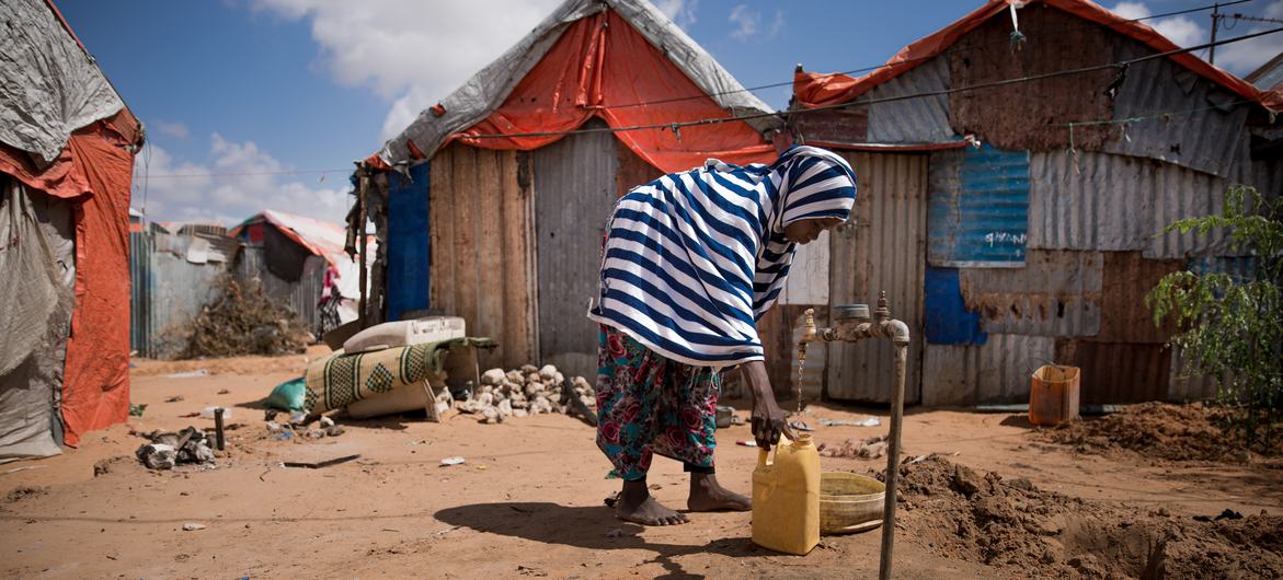 فتاة صغيرة تجمع الماء في مقديشو بالصومال.