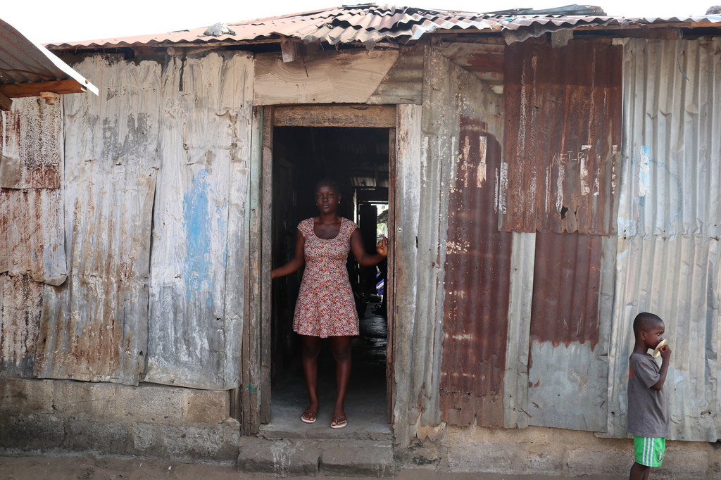 Agnes en la puerta de su casa en Liberia, junto a su hijo.