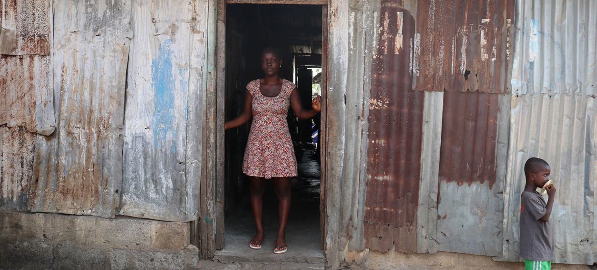 Agnes-Josephine Kenderman and her son stand in front of her home in Liberia.