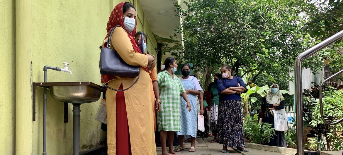نساء ينتظرن دورهن لتلقي قسائم الطعام في عيادة حكومية في كولومبو