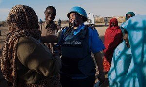 Una policía de UNAMID conversa con mujeres en un punto de sumnistro de agua en el campamento de desplazados de Nifasha, en el norte de Darfur (foto de archivo).