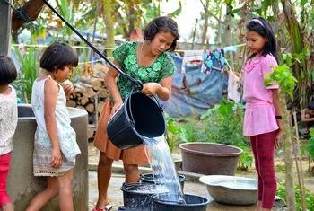 म्याँमार में, देश के भीतर ही विस्थापित हुए लोगों के लिये बनाए गए एक शिविर में, कुछ लड़कियाँ पानी भरते हुए.