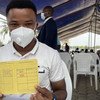 Machad, un agent de santé au Benin, montre fièrement son carnet de vaccination après avoir pris sa première dose du vaccin AstraZeneca. 