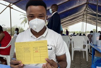 Machad, a health worker in Benin, proudly displays his vaccination record after taking his first dose of AstraZeneca vaccine.