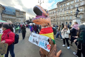 Activist dressed as dinosaur character takes part in demonstrations at the COP26 Climate Conference in Glasgow, Scotland.
