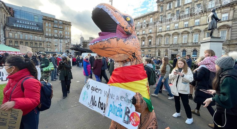 Mwanaharakati akiwa amevalia kikaragosi cha Dinasoria wakati wa maandamano huko Scotland kwenye mkutano wa COP26