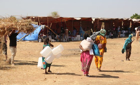 Refugiados recém-chegados de Tigray, na Etiópia, trazem suprimentos para abrigo no campo de Raquba, em Kassala, no Sudão