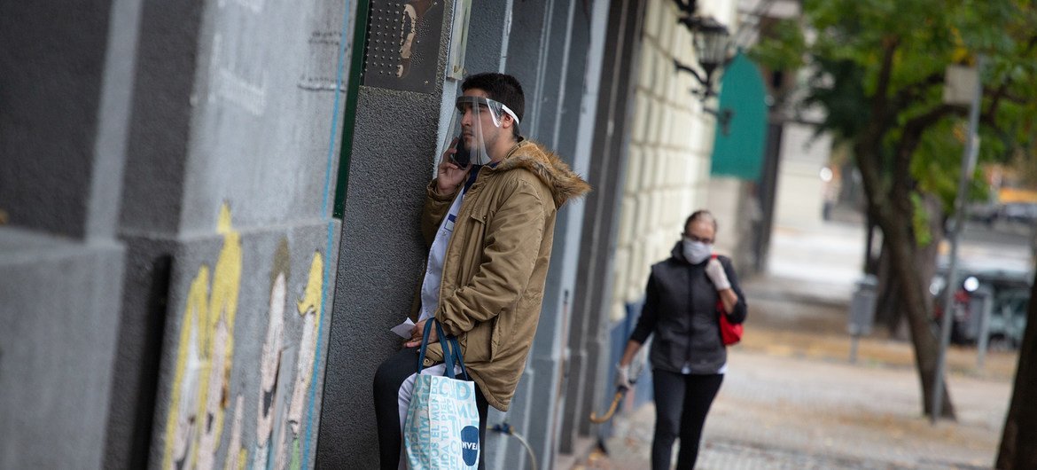 Un hombre habla por teléfono usando una pantalla para protegerse del COVID-19 en Buenos Aires, Argentina. 
