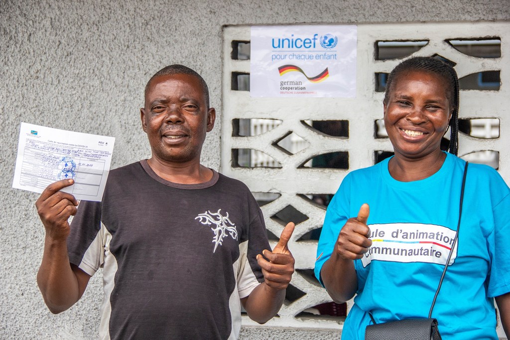 Brigitte Kevani, muhudumu wa kijamii aliyepatiwa mafunzo na UNICEF akiwa na Jean Mulumba aliyehamasika na kupatiwa chanjo dhidi ya COVID-19.