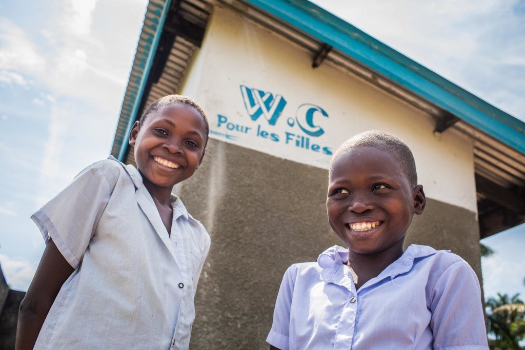 طلاب أعضاء في المجموعة الصحية يقفان خارج مراحيض مدرسة ديكوليلاي الابتدائية في كانانغا، مقاطعة كاساي الغربية، جمهورية الكونغو الديمقراطية
