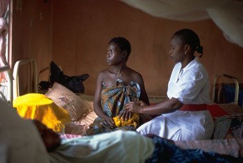 A woman who has had no prenatal care, and whose child was stillborn, is comforted by a nurse in the maternity ward of a hospital in Sierra Leone.